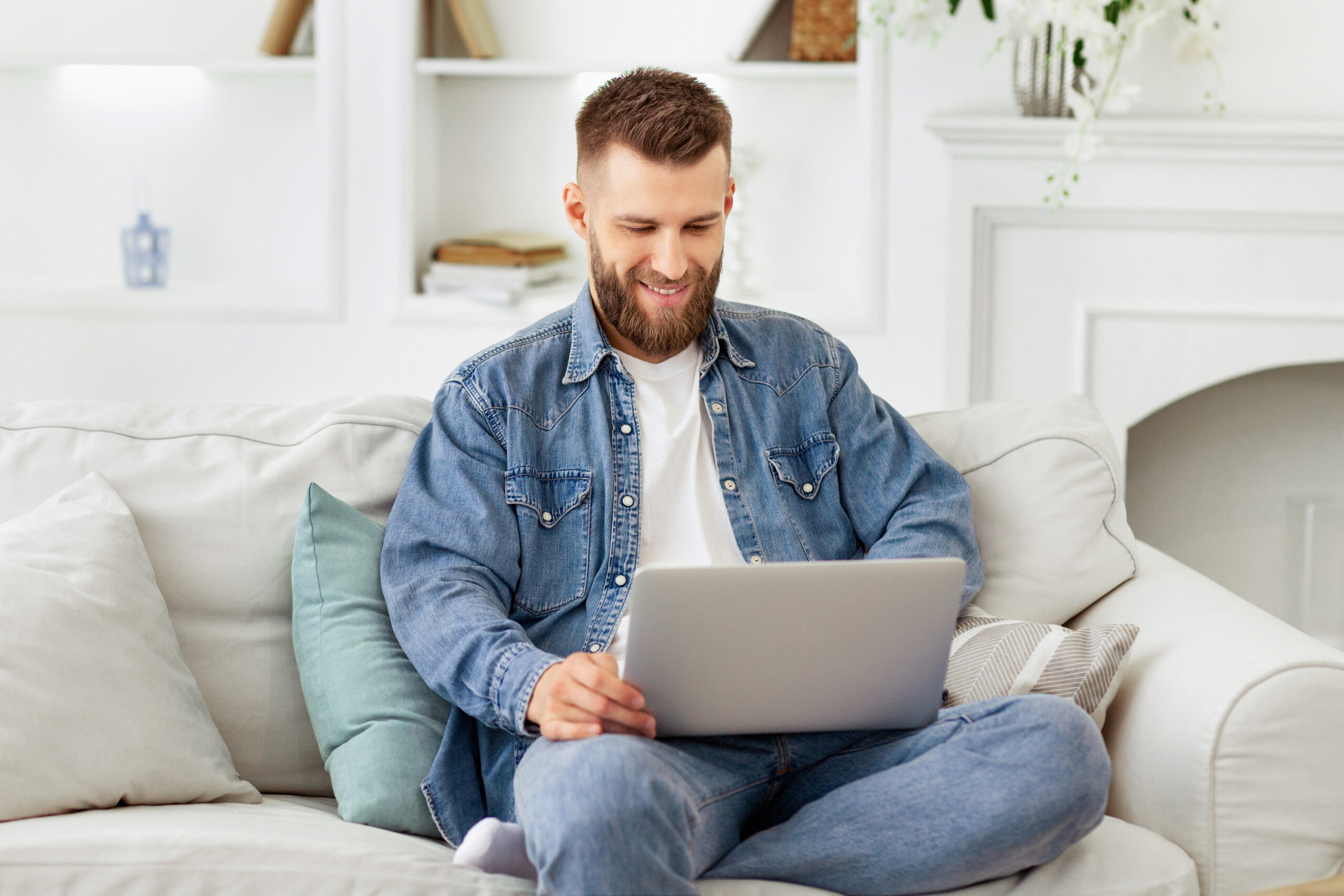 Man Sitting on Couch Using Laptop